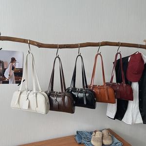 Minimalist leather Boston bags in multiple colors hanging on a rustic branch