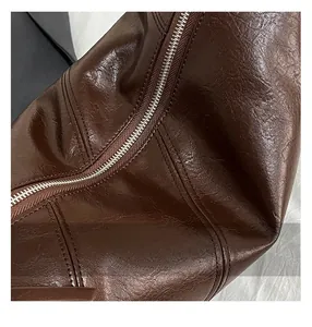 Macro shot of dark brown leather texture with high-quality zipper and stitching details
