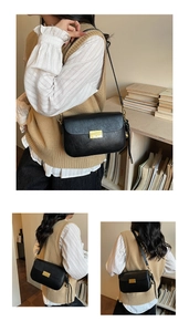 Detail of black matte leather shoulder bag with gold rectangular clasp and side bead