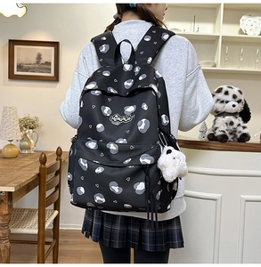 Détail du sac à dos de style coréen avec cœurs blancs, breloque panda et pompons
