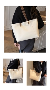 Close-up of cream tote bag featuring V-shaped stitching and dark brown shoulder straps