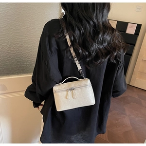 Détail du sac boîte blanc cassé gaufré autruche avec double zip et poignée supérieure