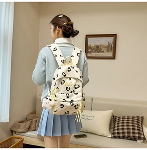 Sac à dos en toile beige à imprimé léopard porté par un mannequin avec peluche