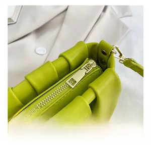 Detail showing the golden metal zipper and pleat texture on this green shoulder bag