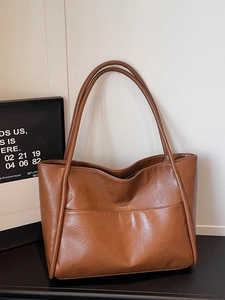 Borsa tote minimalista in pelle marrone con tasca frontale e tracolle lunghe