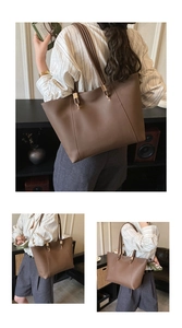 Detail shot of large brown matte leather tote bag with reinforced metal strap buckles