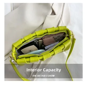 Interior capacity of the lime green pleated cloud bag showing wallet and cosmetics