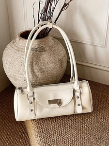Chic beige cylindrical baguette bag with long straps and silver stud details