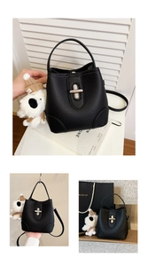 Detailed close-up of a black lychee texture bucket bag with silver twist lock and puppy charm