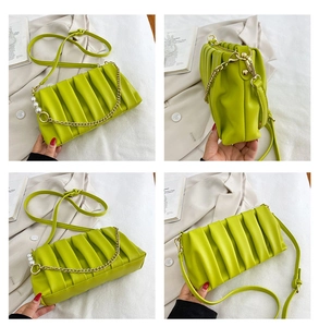 Detail of lime green ruched crossbody bag with pearl chain and adjustable strap