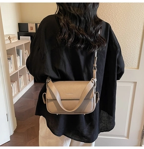 Detailed view of khaki lychee grain leather crossbody bag with flap and metal feet