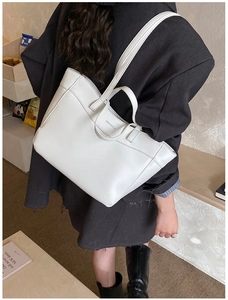 White leather tote bag with brand lettering shown on model for stylish daily use