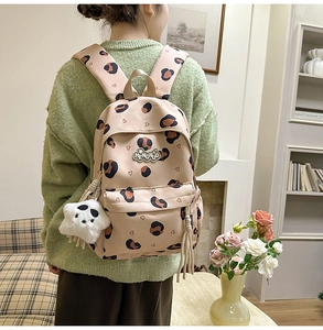 Détail du sac à dos léopard beige avec pendentif étoile en peluche et logo de marque