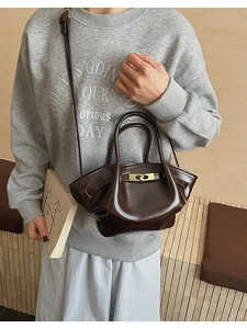 Detail der braunen Vintage-Handtasche aus Kunstleder mit goldenem Drehverschluss und Riemen