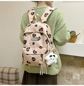 Détail du sac à dos rose à motif léopard avec charm étoile en peluche et logo en métal
