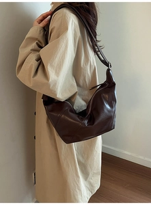 Detail of soft brown leather hobo bag with natural wrinkles and adjustable wide strap