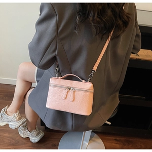 Sac boîte rose à texture autruche porté en bandoulière avec finitions argentées