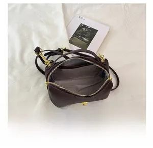 Detail view of brown Boston bag showing spacious interior and golden zipper closure