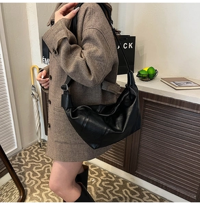 Close-up of black PU leather hobo bag with adjustable strap and silver metal buckle