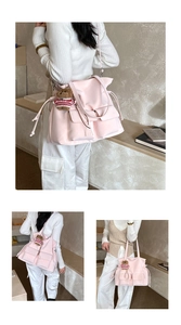 Detailed view of pink tote bag with front pockets and cute bear plush charm accessory