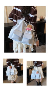 Detail view of light blue drawstring canvas bucket bag with front pockets and teddy bear charm