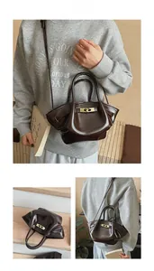 Detail der dunkelbraunen Lackleder-Eimertasche mit goldenem Drehverschluss und Riemen