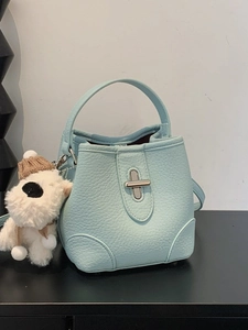 Elegant light blue lychee pattern bucket bag with metal clasp and plush puppy charm