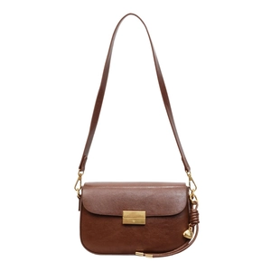 Close-up of brown leather shoulder bag featuring gold metallic clasp and side pendant detail