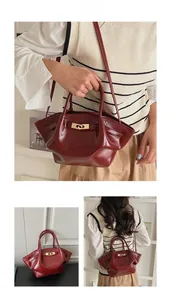 Nahaufnahme einer vintage weinroten Glanzleder-Handtasche mit elegantem Metalldrehverschluss