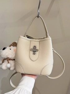 Elegant cream bucket bag in pebble leather with silver twist lock and dual straps
