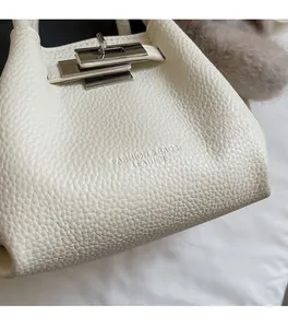 Macro view of white litchi pattern leather with silver rotating metal lock detail