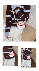 Détail du petit sac bandoulière blanc avec motifs cœurs rouges et pompon décoratif
