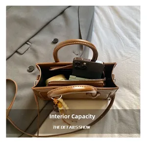 Macro view showing the internal capacity and zipper compartment of this brown leather bag