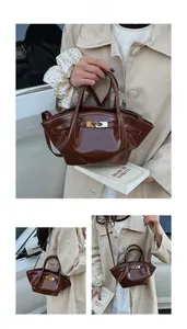 Detail der dunkelbraunen Falten-Handtasche aus glänzendem Leder mit goldener Schnalle