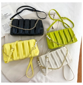 Detail of ruched square handbag with pearl gold chain and adjustable leather strap