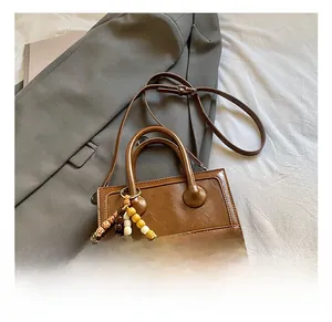 Detailed view of a dark brown vintage textured square handbag with colorful wood beads