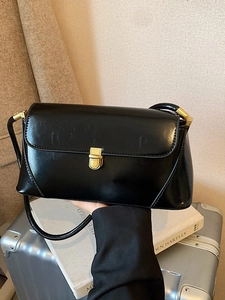 Minimalist black glossy faux leather baguette shoulder bag with vintage gold metal clasp