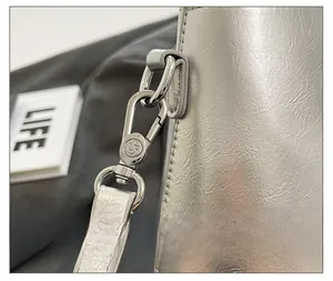 Λεπτομέρεια από ασημί μεταλλικό κούμπωμα και δερμάτινη υφή σε κομψή τσάντα κουβά