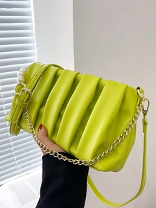 Lime green pleated crossbody bag with a chunky gold chain strap and pearl charm