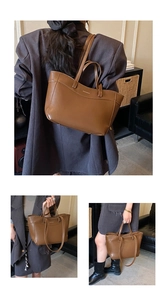 Detail of dark brown leather tote bag with four straps and embossed brand logo