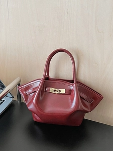 Vintage bordeauxrote Lederhandtasche mit goldenem Metalldrehverschluss und Fledermaus-Design