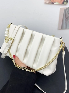White ruched square bag with gold chain and pearl charms shown as a top handle bag
