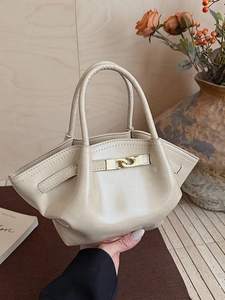 Elegante beige Tasche in Schmetterlingsform mit glänzendem Leder und Goldakzenten