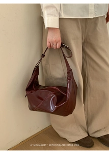Detailed view of the dark red hobo bag with adjustable strap and glossy leather finish