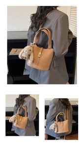 Detail of camel lychee leather bucket bag with metal lock and cute plush rabbit charm