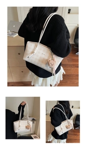 Detail of light beige plaid tote bag featuring long straps and a plush bear charm