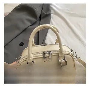 Detail of off-white PU leather handbag with dual zippers and decorative checkered bow