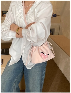 Detailed shot of pink pleated cloud bag with cartoon embroidery and drawstring closure