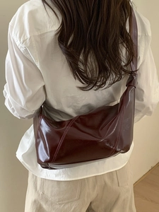 Burgundy high-shine leather saddle bag shown in a stylish 45-degree crossbody view