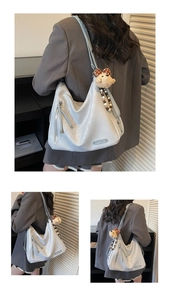 Détail d'un grand cabas en cuir bleu clair avec breloque peluche et zip latéral